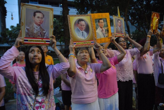 Holding portraits of His Majesty the King, well-wishers camp out on Wednesday to pray for King Bhumibol at Siriraj Hospital in Bangkok.